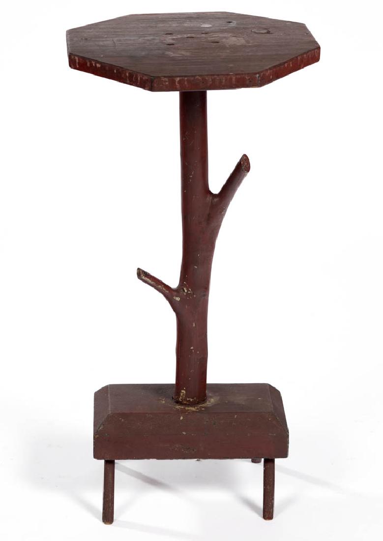 AMERICAN FOLK ART PAINTED ROOT / TWIG STAND TABLE: AMERICAN FOLK ART PAINTED ROOT / TWIG STAND TABLE, octagonal top applied to root / twig, raised on a foot stool base. Retains an old red-painted surface. First quarter 20th century. 29 3/4" HOA. Very 