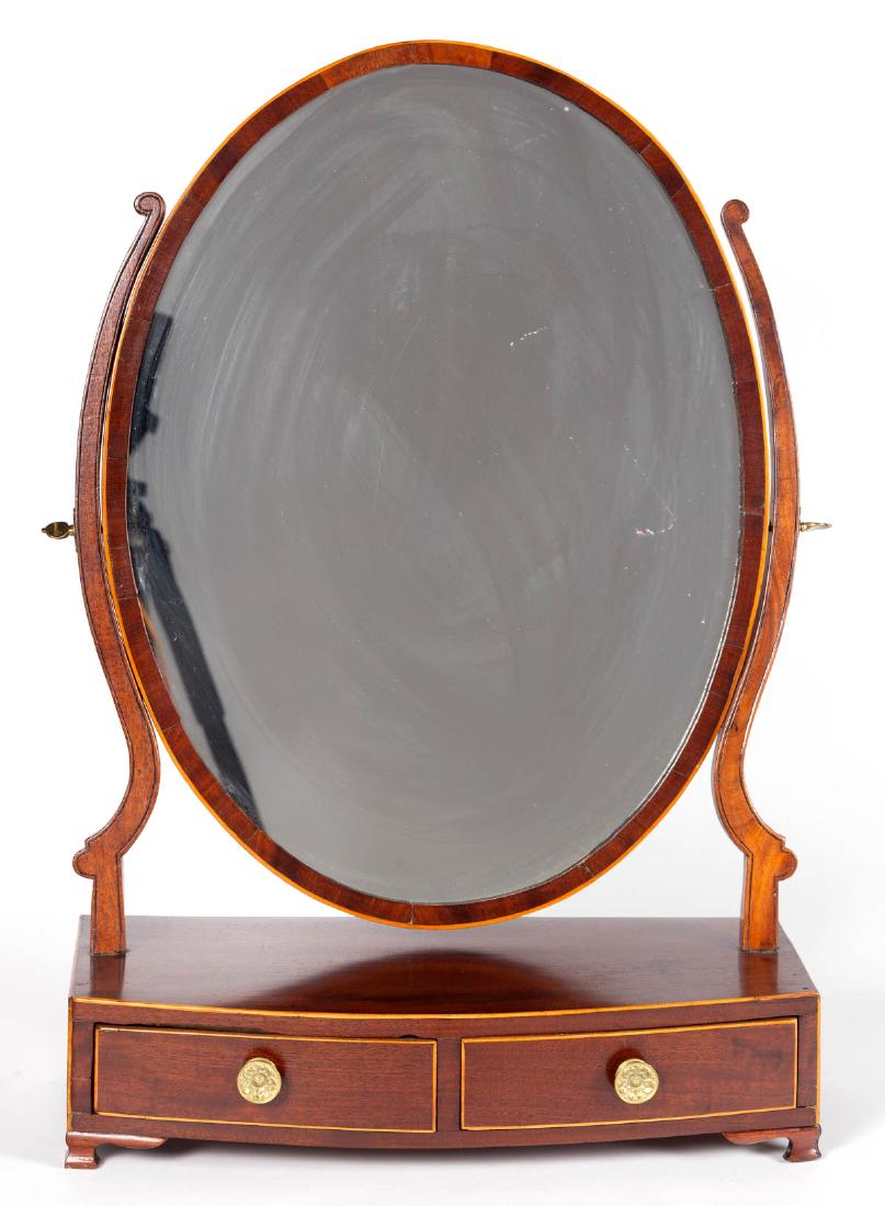 AMERICAN MAHOGANY DRESSING MIRROR: AMERICAN MAHOGANY DRESSING MIRROR, oval mirror frame, two drawers with brass pulls, the whole raised on ogee feet. Original mirror plate and backing boards. Retains original surface. Circa 1830. 24 3/
