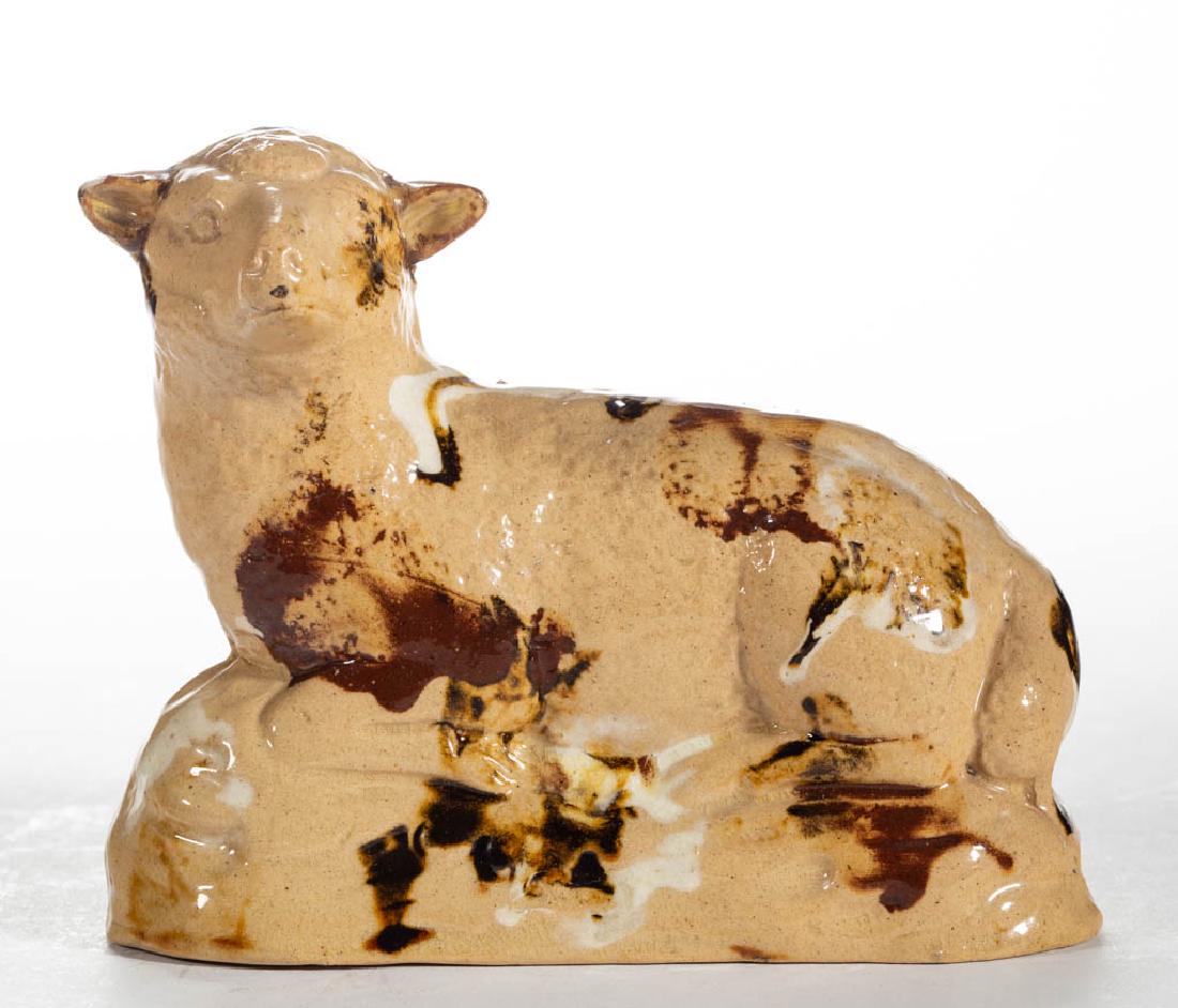 ENGLISH YELLOWWARE CERAMIC SHEEP FIGURE: ENGLISH YELLOWWARE CERAMIC SHEEP FIGURE, recumbent on a molded oval base, having brown and white slip decoration, decorated in the round, open-bottomed. Having "J 635 82" written on underside. Early 1