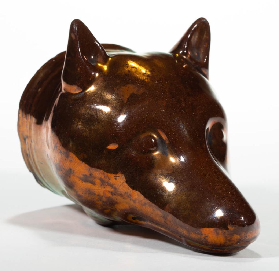 ENGLISH STAFFORDSHIRE COPPER LUSTRE CERAMIC FOX STIRRUP: ENGLISH STAFFORDSHIRE COPPER LUSTRE CERAMIC FOX STIRRUP CUP, having raised ears and molded collar. Circa 1830. 4 3/8" HOA, 2 5/8" D.Some areas of wear and loss to lustre, with a few minor to moderate