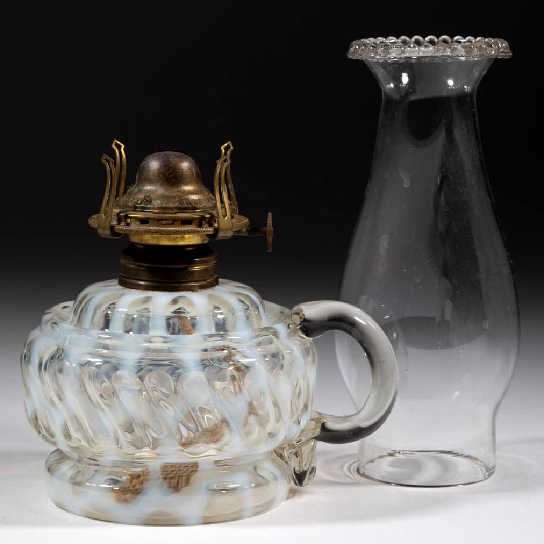 MARKHAM SWIRL BAND - BIG WINDOWS KEROSENE FOOTED FINGER: MARKHAM SWIRL BAND - BIG WINDOWS KEROSENE FOOTED FINGER LAMP, colorless opalescent, with molded swirls on body, colorless applied handle with pressed rib pattern to lower terminal, No. 1 Taplin-Brown 