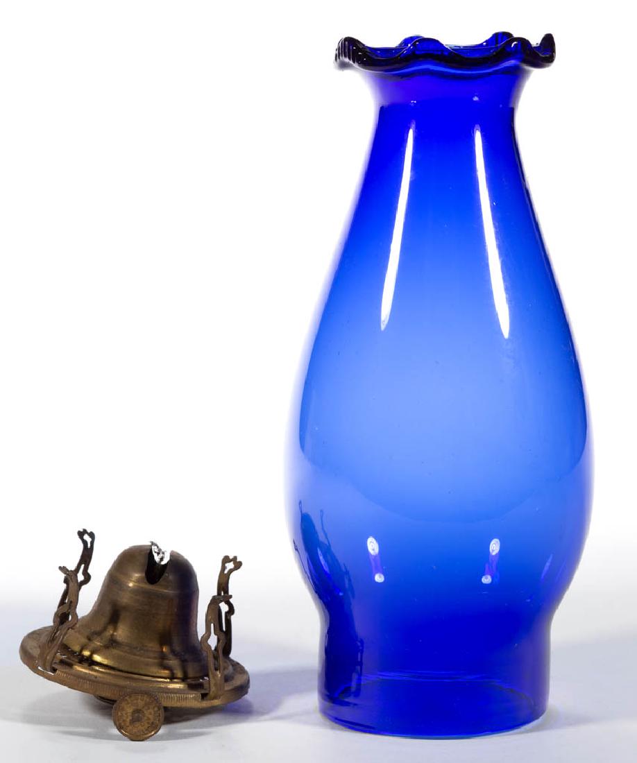 COBALT BLUE NO. 1 SLIP CHIMNEY SETUP: COBALT BLUE NO. 1 SLIP CHIMNEY SETUP, serrated-scalloped rim. Fitted on a Bridgeport Brass Co. slip burner. Fourth quarter 19th century. 8" HOA. Undamaged. Provenance: From the Joe Cesarini estate col