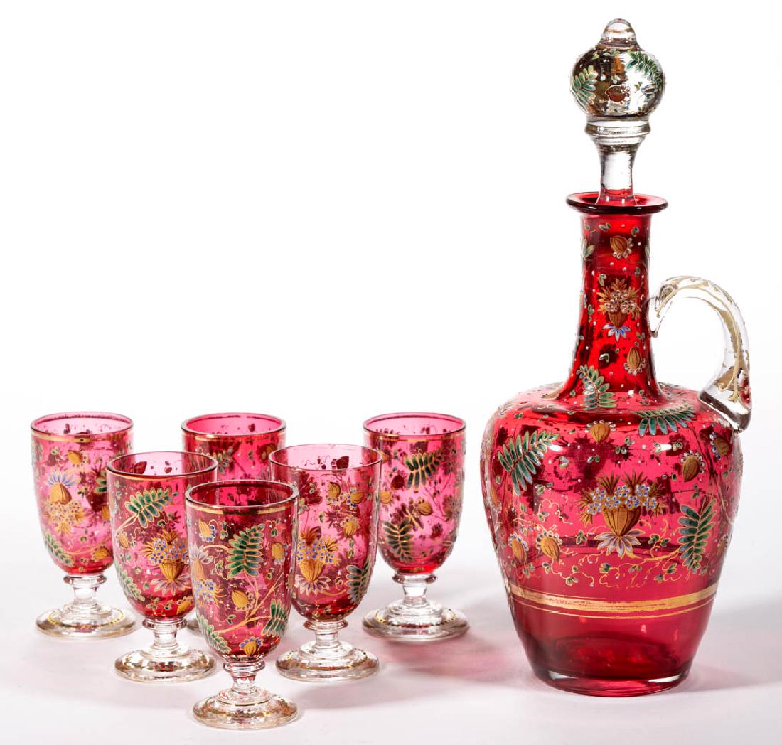 MOSER ATTRIBUTED ENAMEL-DECORATED SEVEN-PIECE LIQUOR: MOSER ATTRIBUTED ENAMEL-DECORATED SEVEN-PIECE LIQUOR SET, cased cranberry with matching polychrome-enamel decoration, comprising a small ewer and six footed wine/liquor glasses, ewer with original sto