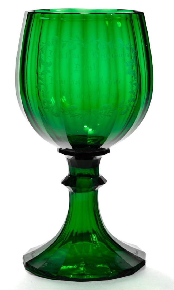 BOHEMIAN CUT-PANELLED AND ENGRAVED PRESENTATION CHALICE: BOHEMIAN CUT-PANELLED AND ENGRAVED PRESENTATION CHALICE, emerald green, 15-panel ovoid bowl, single-knop and flaring foot, central reserve stating "Dem treuen Kegelvater/Danf!/Dem beltin Kegler/Ohr un
