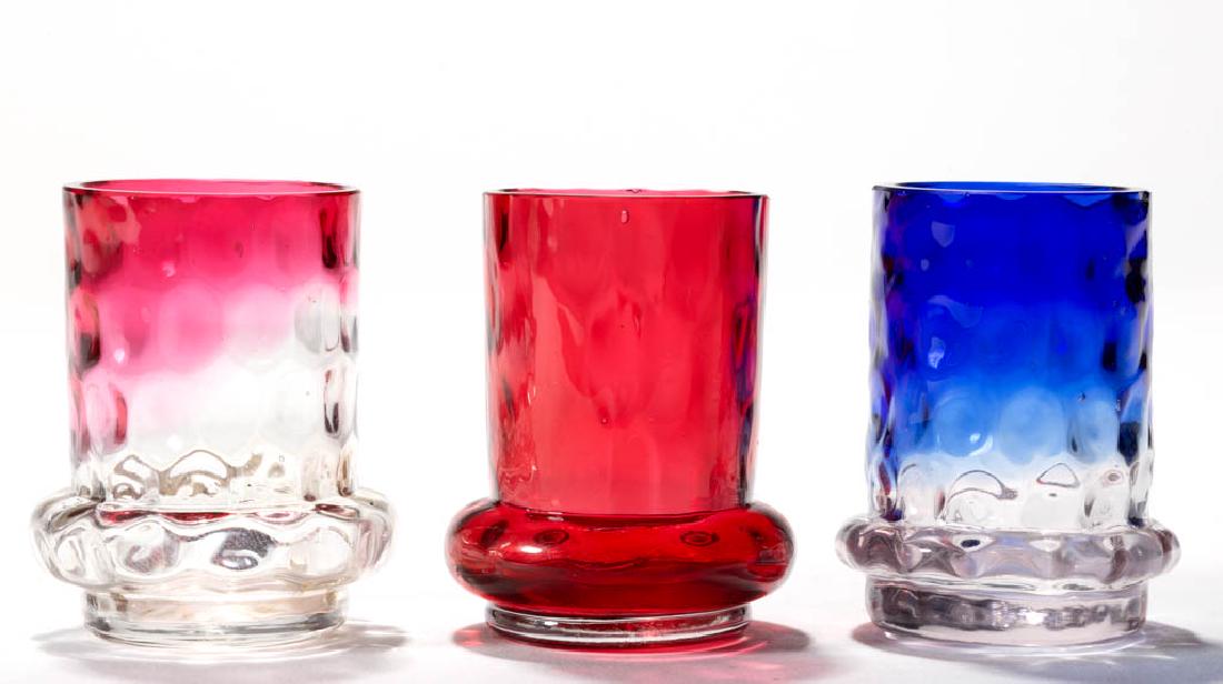 BULGE BASE INVERTED THUMBPRINT / SPOT-OPTIC TOOTHPICK: BULGE BASE INVERTED THUMBPRINT / SPOT-OPTIC TOOTHPICK HOLDERS, LOT OF THREE, blurina, cranberry, and rubina, each with factory polished rim. Fourth quarter 19th century. 2 1/4" H.Undamaged.Literature: