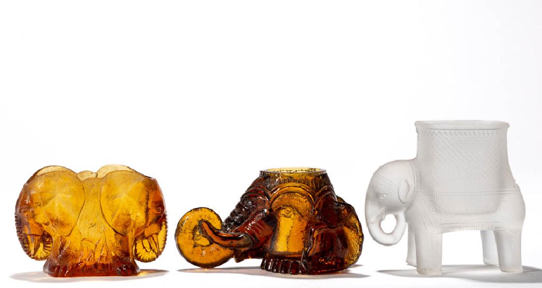 ASSORTED NOVELTY ELEPHANT TOOTHPICK HOLDERS, LOT OF: ASSORTED NOVELTY ELEPHANT TOOTHPICK HOLDERS, LOT OF THREE, frosted colorless and amber, comprising Findlay Elephant Head, Twin Elephants, and Baby Mine. Fourth quarter 19th century. 2 3/8" to 3 1/2" H