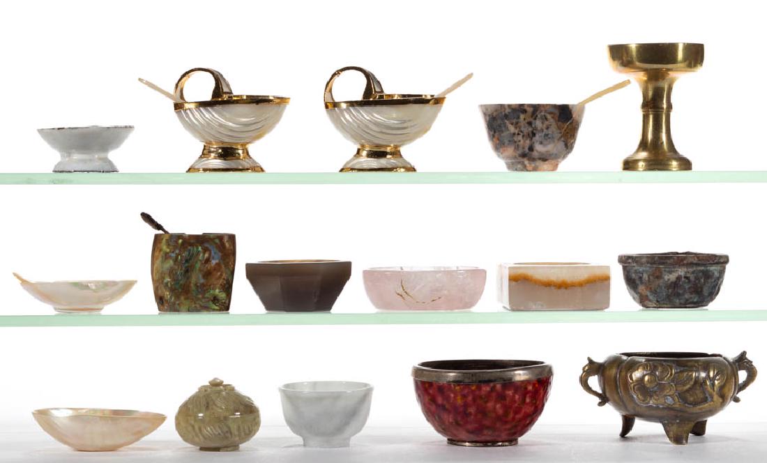 STONE AND OTHER OPEN SALTS AND SALT SPOONS, LOT OF 21: STONE AND OTHER OPEN SALTS AND SALT SPOONS, LOT OF 21, materials include stone, shell, brass, and enameled metal, featuring one covered stone salt. Asian and others. Late 19th/20th century. Various si