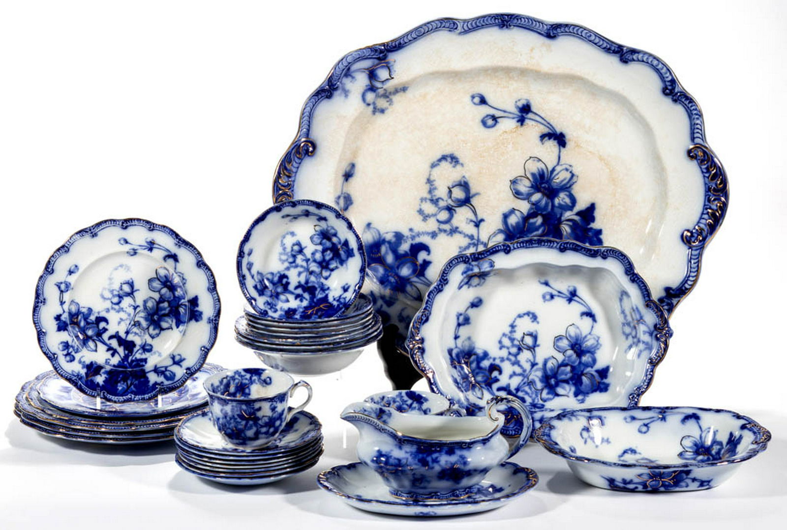 ENGLISH STAFFORDSHIRE FLOW BLUE "SUTTON" PATTERN: ENGLISH STAFFORDSHIRE FLOW BLUE "SUTTON" PATTERN IRONSTONE TABLE ARTICLES, LOT OF 29, including an ovoid platter, an oval serving dish, a footed vegetable dish, a sauce boat with underplate, three 10"
