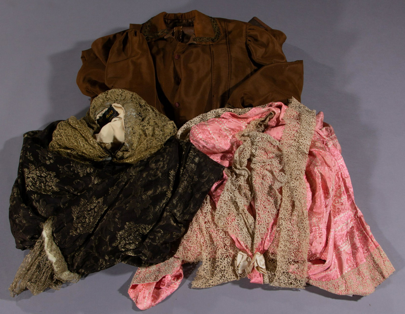 VICTORIAN / EDWARDIAN COATS AND ROBE, LOT OF THREE: VICTORIAN / EDWARDIAN COATS AND ROBE, LOT OF THREE, comprising a pink printed silk robe with lace detailing, a brown wool raincoat with buttons down the front and polished cotton interior lining, and 