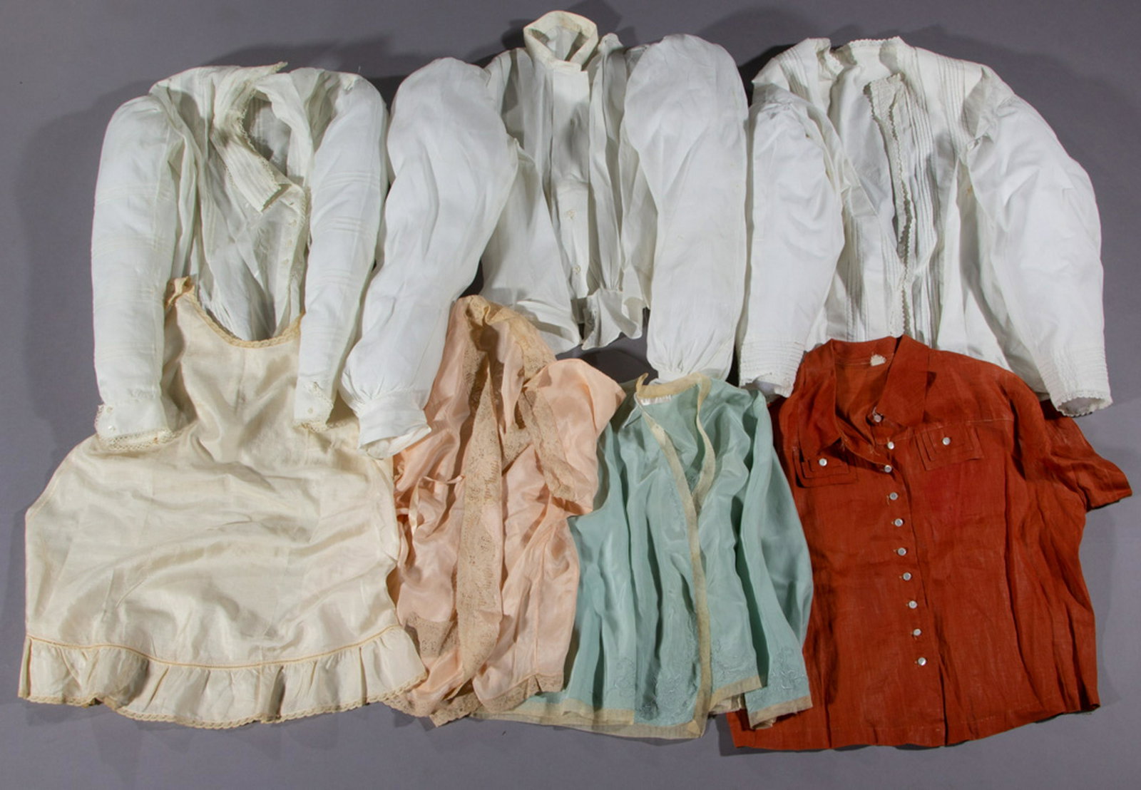 ANTIQUE / VINTAGE SHIRTS AND BLOUSES, LOT OF SEVEN: ANTIQUE / VINTAGE SHIRTS AND BLOUSES, LOT OF SEVEN, including a peach and a mint green satin bed jacket, each with lace trim, a short sleeve burnt orange linen shirt with faux pockets, and three white