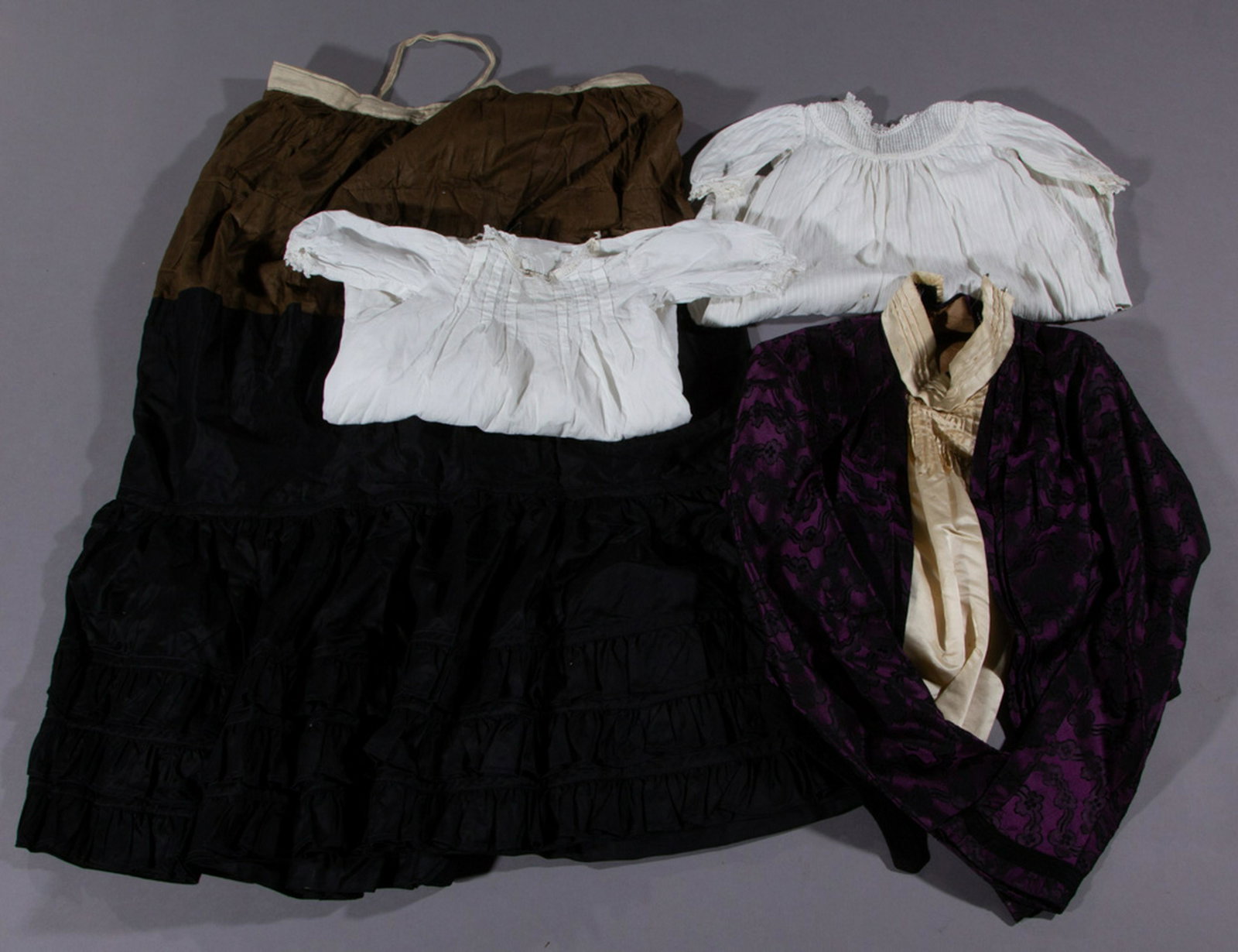 VICTORIAN / EDWARDIAN CLOTHING ARTICLES, LOT OF FOUR: VICTORIAN / EDWARDIAN CLOTHING ARTICLES, LOT OF FOUR, comprising a purple and black lady's bodice having a cream-colored front and high collar with interior boning, a black and brown petticoat with la