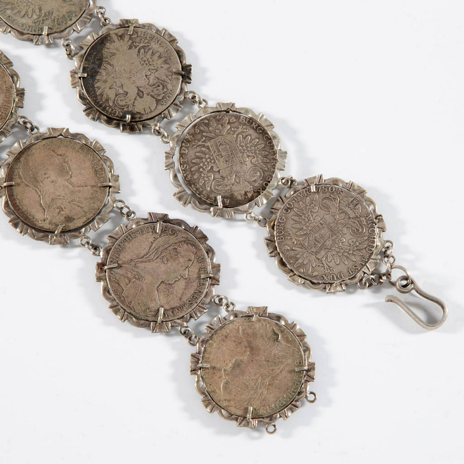 MARIA THERESA THALER SILVER BELT: MARIA THERESA THALER SILVER BELT, comprising 14 restrike Maria Theresa thaler coins with an approximate 0.833 silver fineness, mounted in unmarked silver settings with jump ring connectors. Total weig