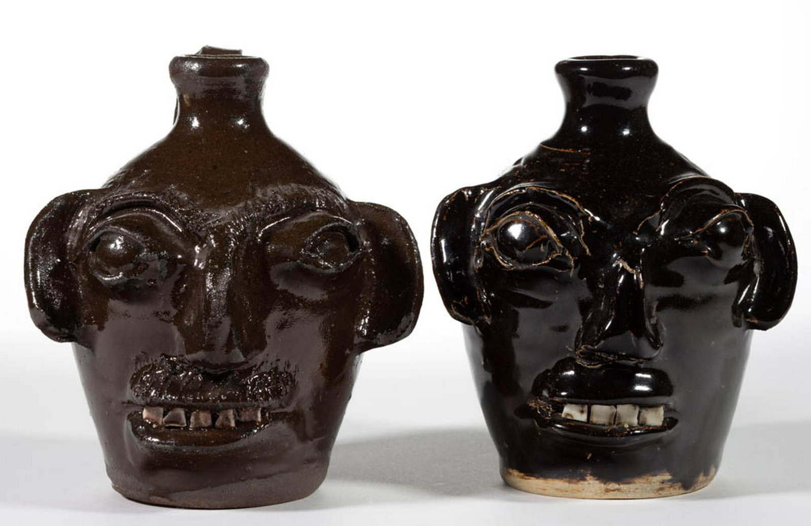 STAMPED "B.B. CRAIG / VALE, N.C." (1914-2002), NORTH: STAMPED "B.B. CRAIG / VALE, N.C." (1914-2002), NORTH CAROLINA STONEWARE FACE JUGS, LOT OF TWO, Albany-slip glazed, each hand-modeled with applied clay face, including bulging eyes with eyebrows, large
