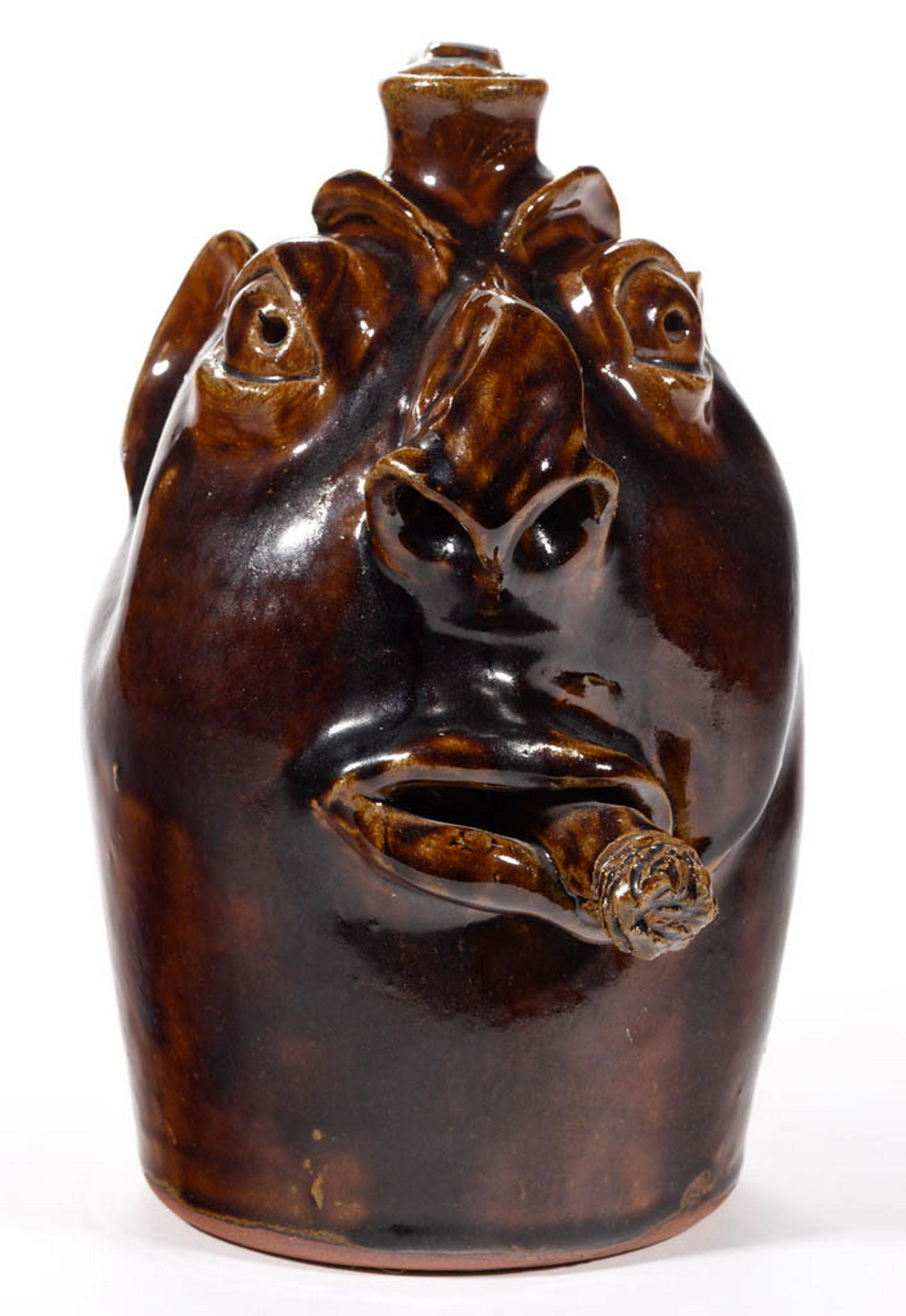SIGNED "ROBERT BROWN", ARDEN, NORTH CAROLINA STONEWARE: SIGNED "ROBERT BROWN", ARDEN, NORTH CAROLINA STONEWARE FACE JUG, Albany-slip glazed, featuring molded eyebrows, clay eyes with incised pupils, protruding crooked nose with wide nostrils, and smoking a