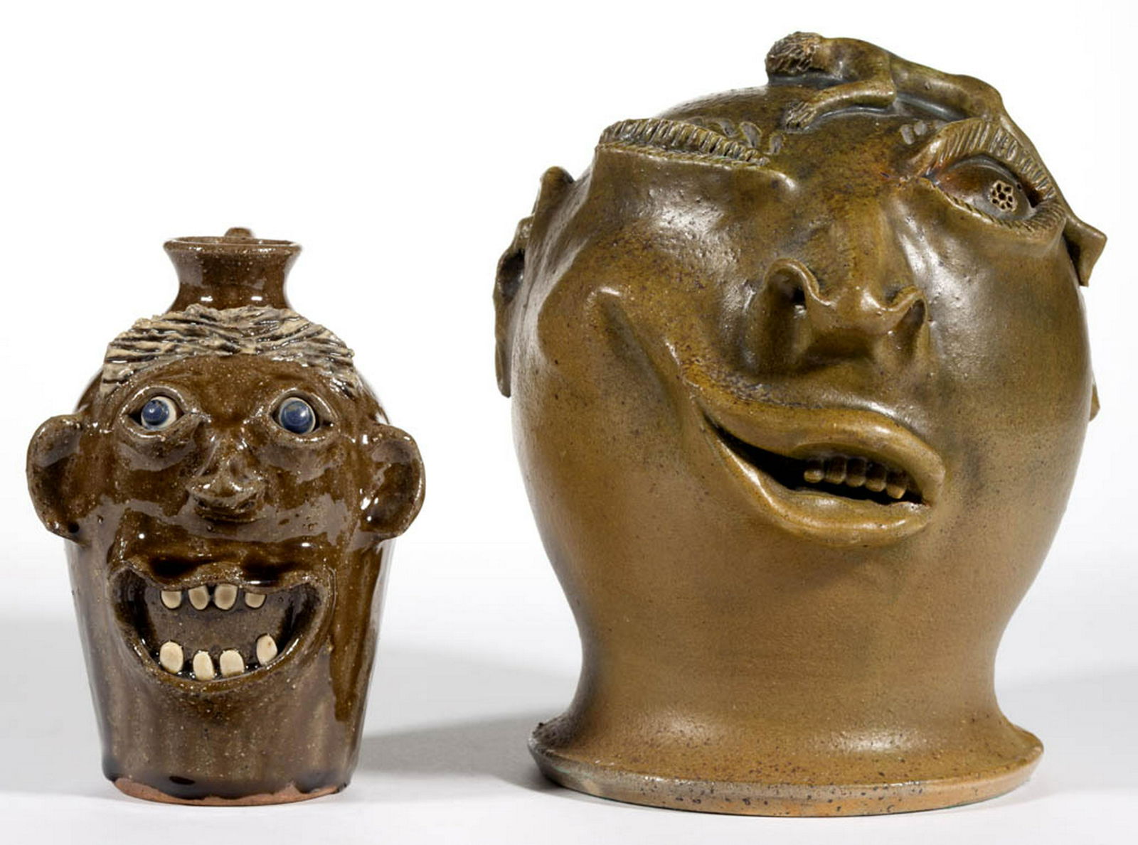 SIGNED BILLY RAY HUSSEY, NORTH CAROLINA, EARTHENWARE: SIGNED BILLY RAY HUSSEY, NORTH CAROLINA, EARTHENWARE FACE JUG BANK, olive-glazed, expressive form having a winking expression, incised eyebrows and eyelashes, nose with pierced nostrils, ears, and an