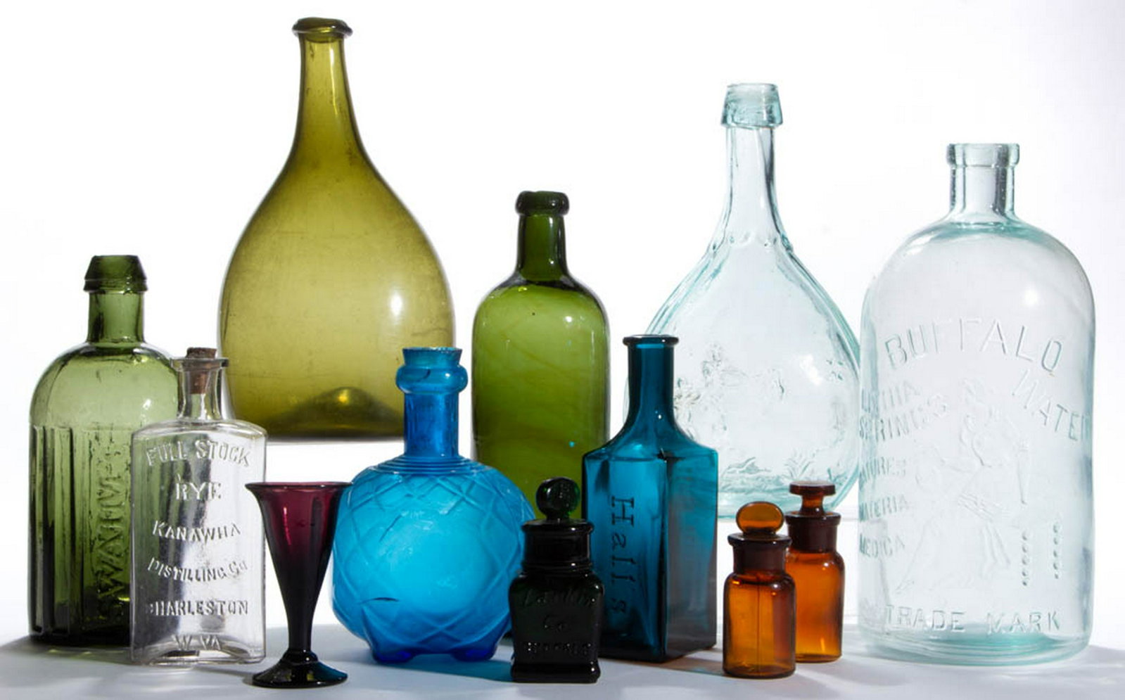ASSORTED GLASS BOTTLES / FLASKS, LOT OF 12: ASSORTED GLASS BOTTLES / FLASKS, LOT OF 12, various colors, including an olive green "SWAIM'S" without pontil mark, an olive green free-blown chestnut bottle, and an aqua "BUFFALO LITHIA SPRINGS" wate