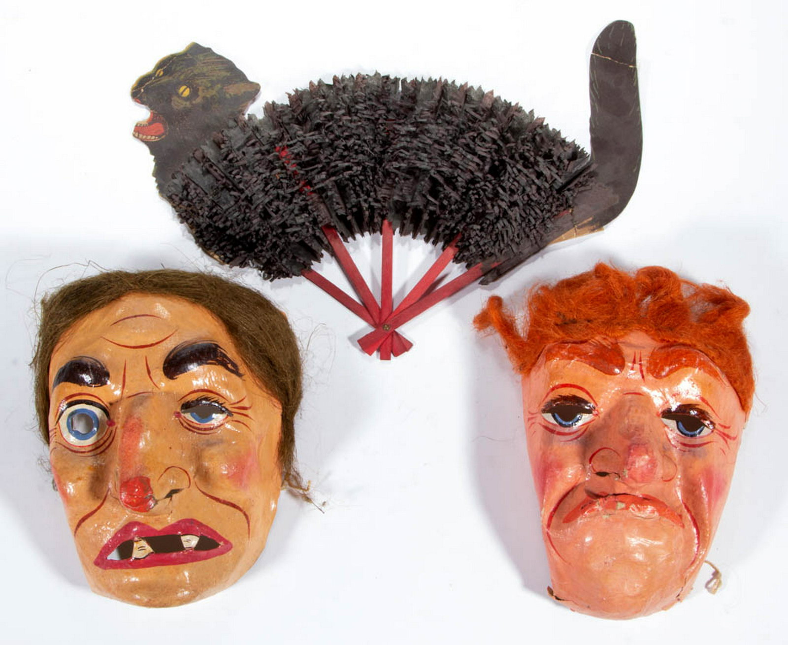 VINTAGE HALLOWEEN ARTICLES, LOT OF THREE: VINTAGE HALLOWEEN ARTICLES, LOT OF THREE, comprising two papier-mache masks with painted exteriors and faux hair, and a black cat hand fan with crepe paper body and lithograph die cut paper head and t