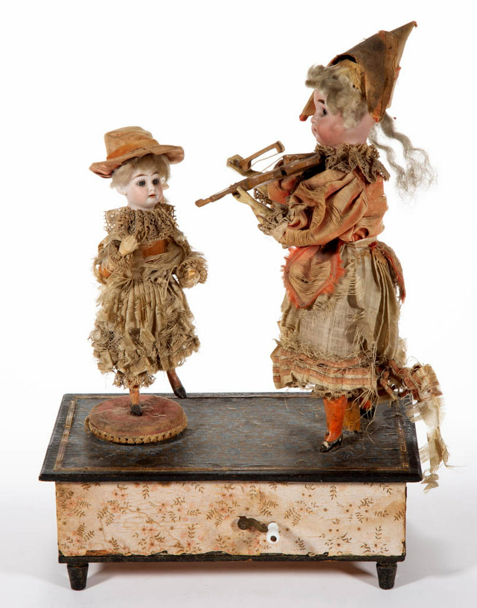 FRENCH BISQUE-HEAD DOLL AUTOMATON: FRENCH BISQUE-HEAD DOLL AUTOMATON, each having fixed eyes, open mouth with teeth, wooden limbs, wearing hat and dress, one figure playing the violin with turning head and moving right arm holding bow,