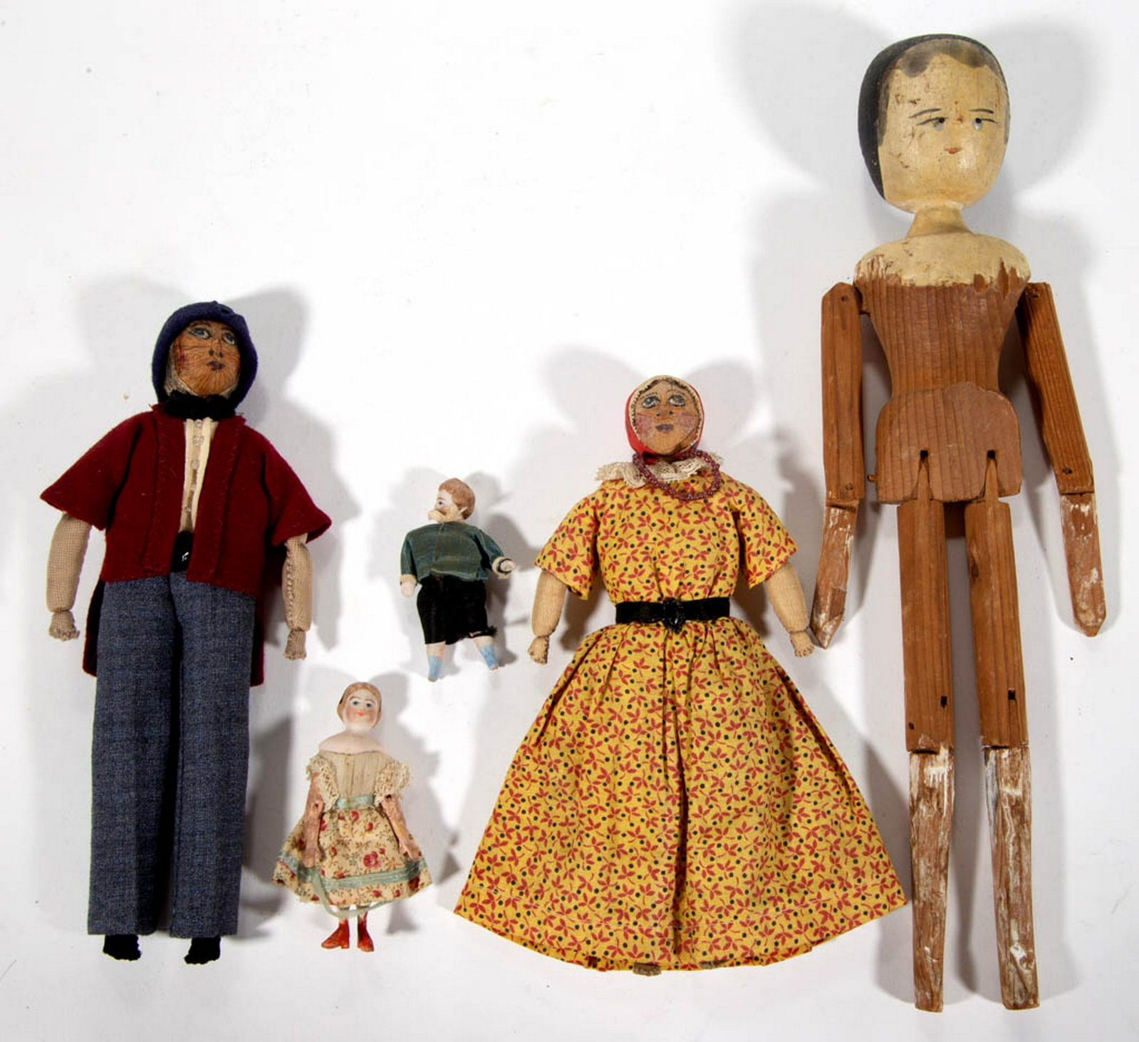 WOODEN AND OTHER DOLLS, LOT OF FIVE: WOODEN AND OTHER DOLLS, LOT OF FIVE, comprising a "Jennie" wooden example with carved and jointed body having painted features, a male and female rag examples with nutshell heads, a bisque head miniat