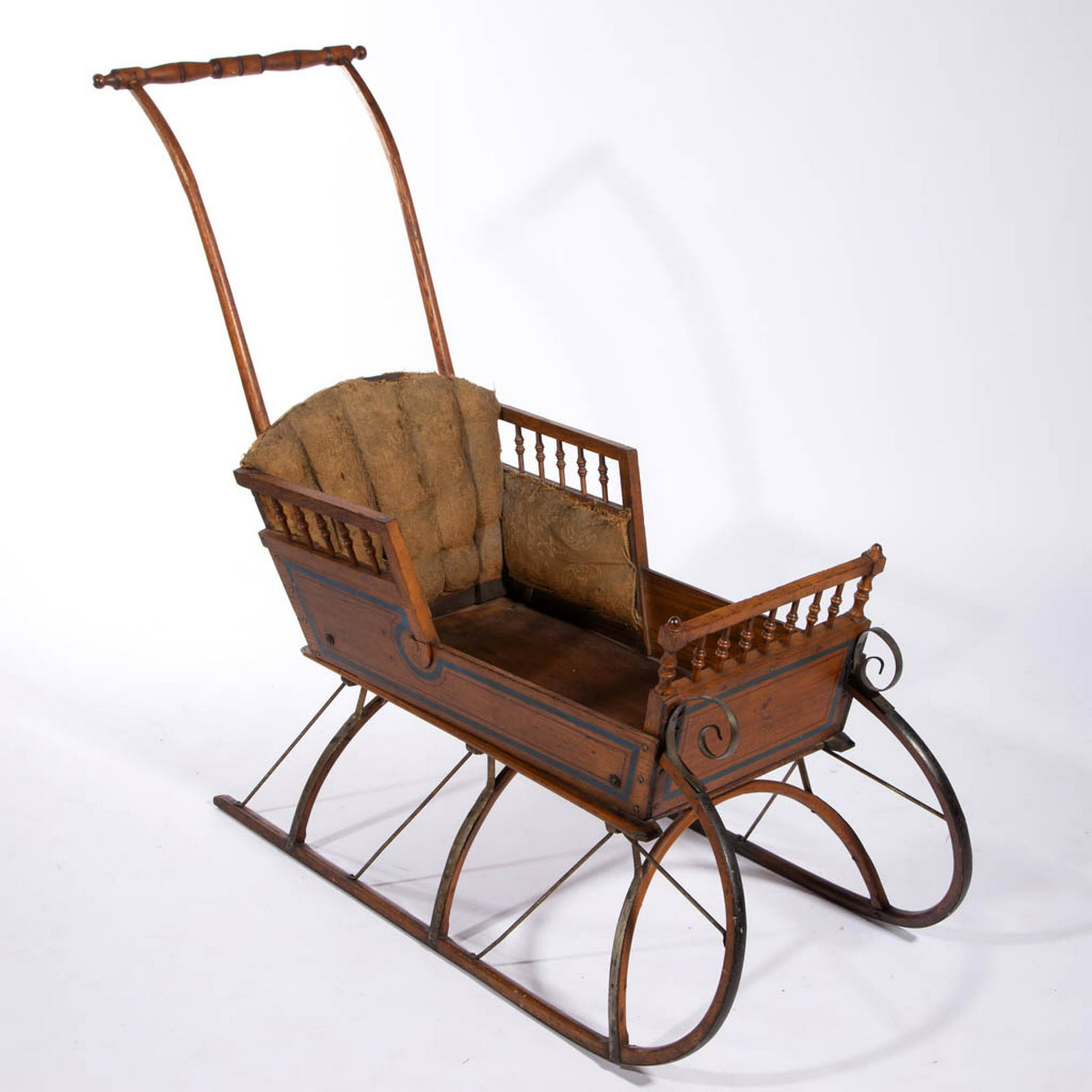 AMERICAN OAK CHILD'S PUSH SLEIGH: AMERICAN OAK CHILD'S PUSH SLEIGH, original varnished body with painted highlights, bentwood and turned handle, upholstered interior, iron runners. Late 19th/early 20th century. 19" W x 39" H x 46" L o