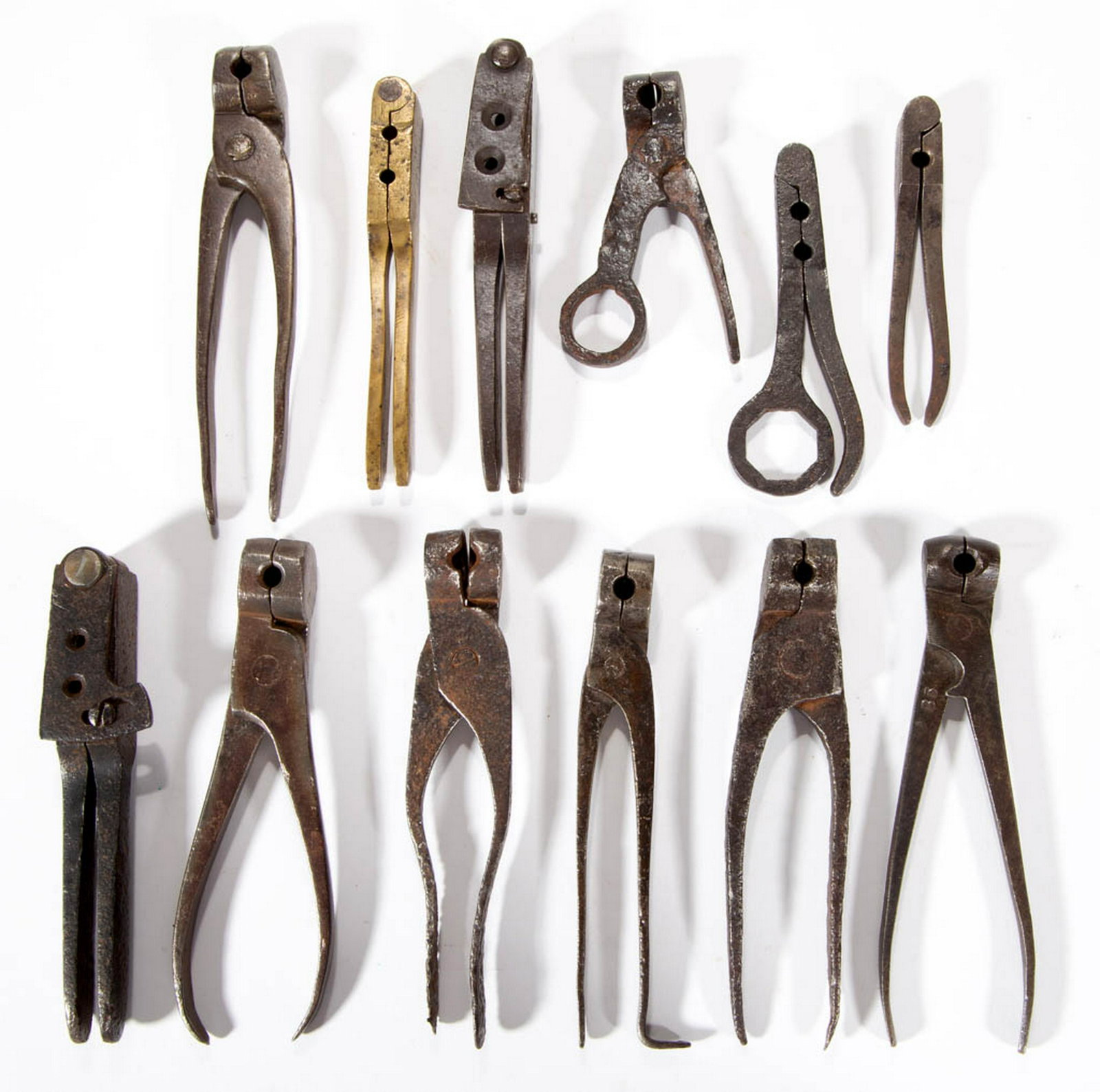 ASSORTED BRASS AND IRON HUNTING ACCOUTREMENTS, LOT OF: ASSORTED BRASS AND IRON HUNTING ACCOUTREMENTS, LOT OF 12, comprising 12 bullet molds, including one brass example, another stamped "85". Late 18th/19th century. Brass example 4 1/2" L. Fair to very go