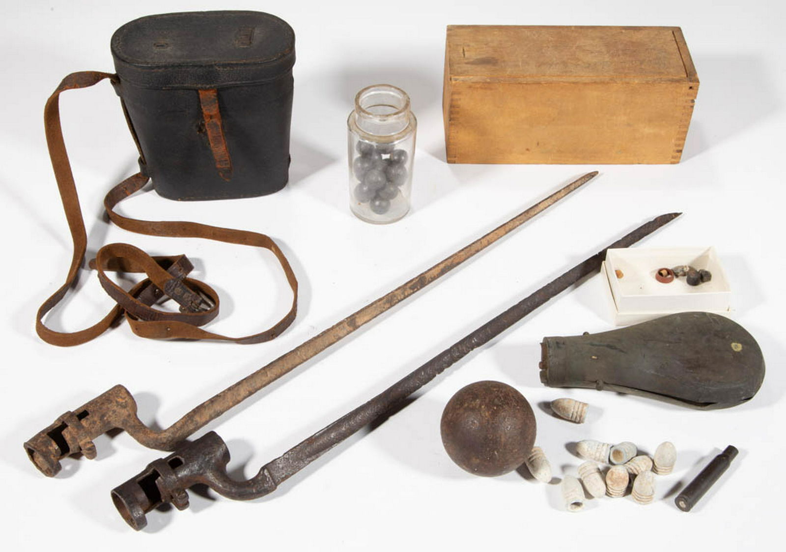 ASSORTED CIVIL WAR ERA ACCOUTREMENTS, UNCOUNTED LOT: ASSORTED CIVIL WAR ERA ACCOUTREMENTS, UNCOUNTED LOT, including .58 caliber minie balls, solid shot canon ball, and leather binocular case, and two bayonets. 19th century. Bayonet 20 1/2" L.Losses to t