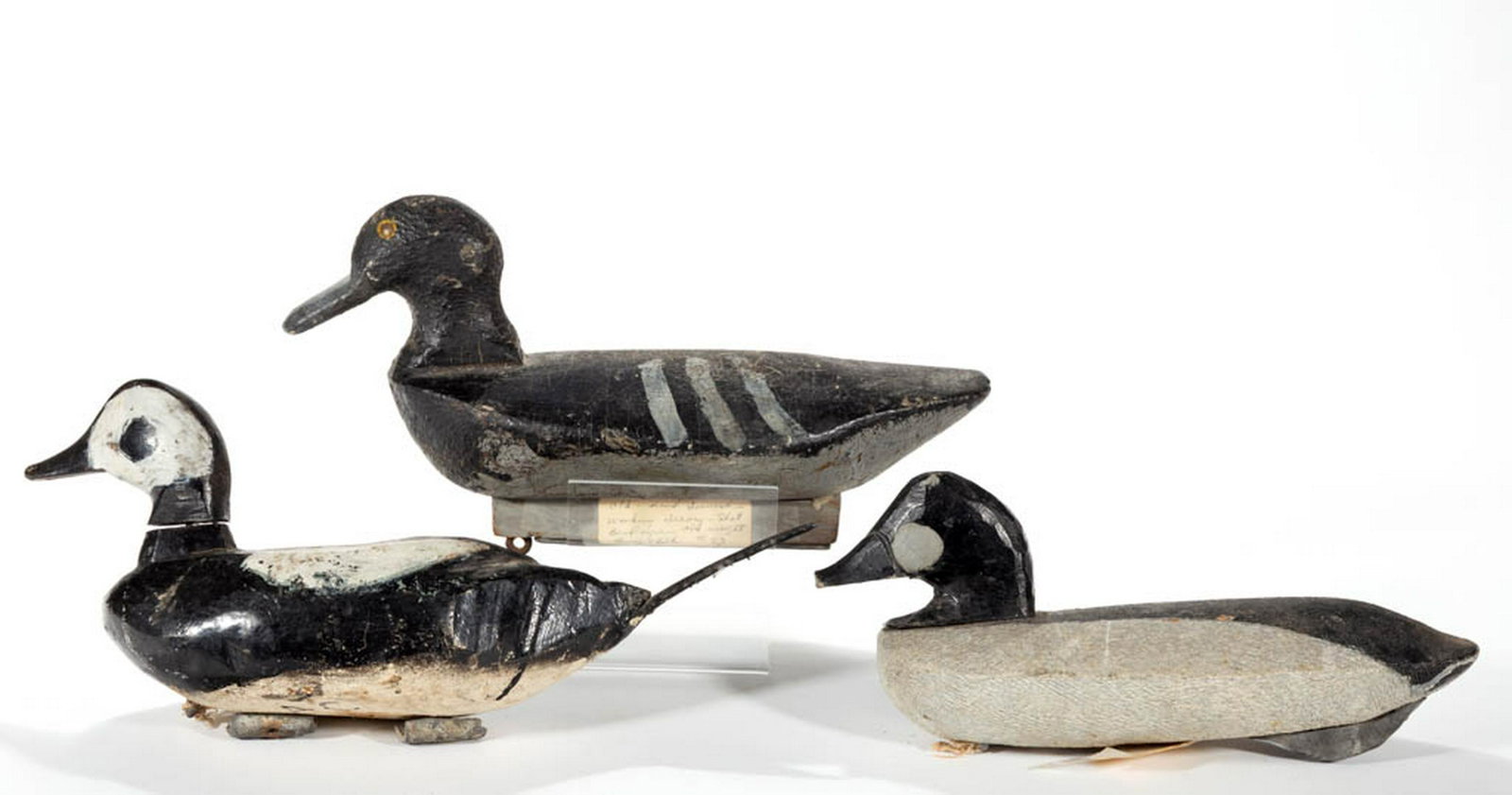 FOLK ART CARVED AND PAINTED DUCK DECOYS, LOT OF THREE: FOLK ART CARVED AND PAINTED DUCK DECOYS, LOT OF THREE, each with solid-body form and weight to base, including one example with metal tack eyes and one with an attached rubber tail and "AC" initials t