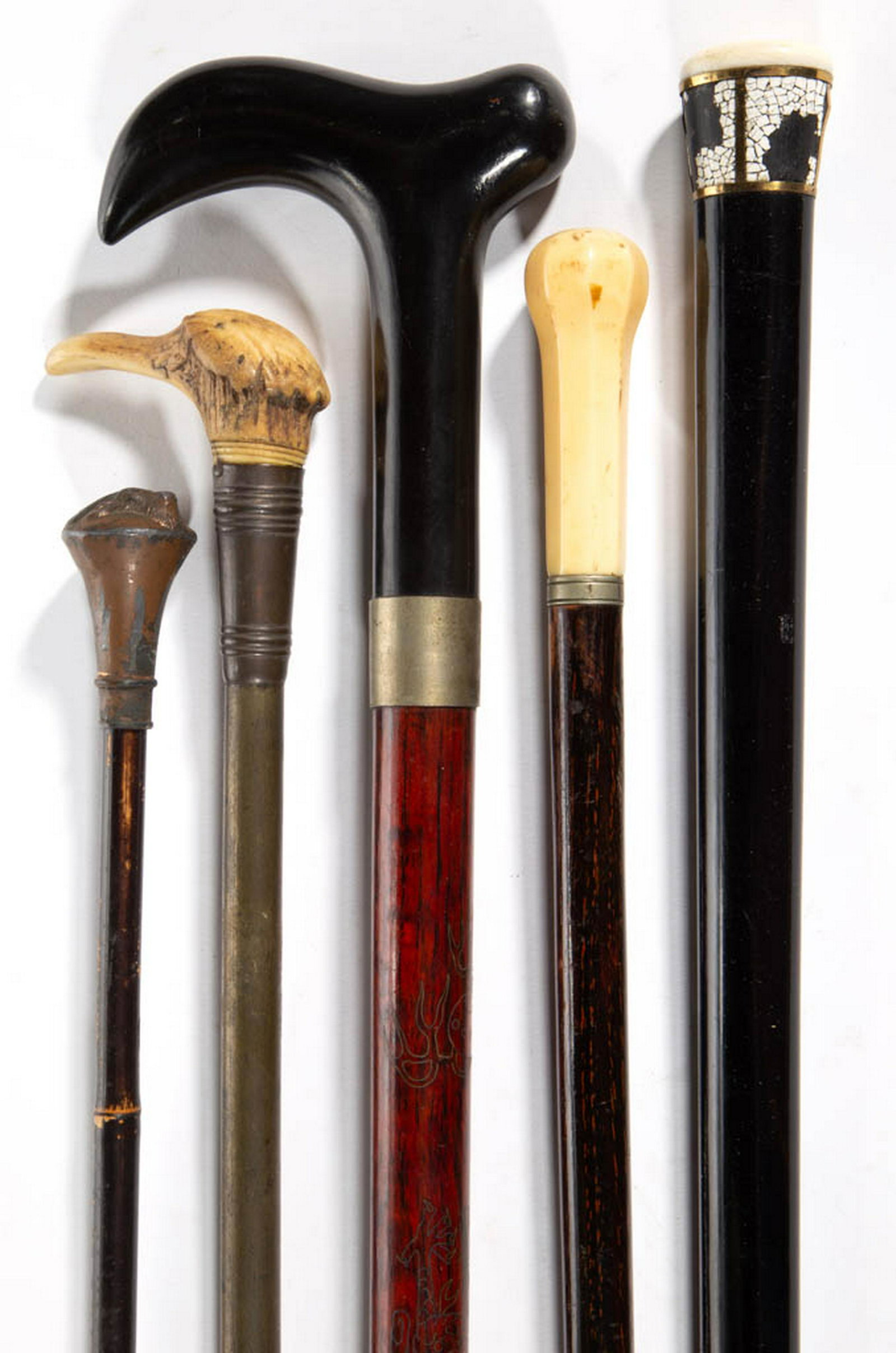 ASSORTED AMERICAN OR CONTINENTAL CANES / WALKING: ASSORTED AMERICAN OR CONTINENTAL CANES / WALKING STICKS, LOT OF FIVE, including one with handle embossed with a stag head. Late 19th/early 20th century. 35" to 35 1/2" L. Good overall condition, each 