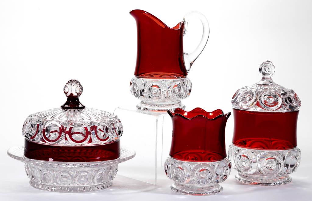 CO-OP'S ROYAL - RUBY-STAINED FOUR-PIECE TABLE SET: CO-OP'S ROYAL - RUBY-STAINED FOUR-PIECE TABLE SET, colorless, comprising a covered butter dish, covered sugar bowl, creamer, and spooner. Co-Operative Flint Glass Co. Pattern introduced in 1894. 4 1/2