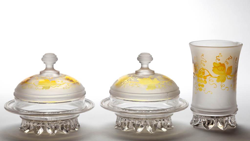 DUNCAN NO. 89 / RIBBED DROPLET BAND - AMBER-STAINED: DUNCAN NO. 89 / RIBBED DROPLET BAND - AMBER-STAINED TABLE ARTICLES, LOT OF THREE, frosted colorless with matching foliate decoration, comprising two covered butter dishes and a celery vase. Geo. Dunca