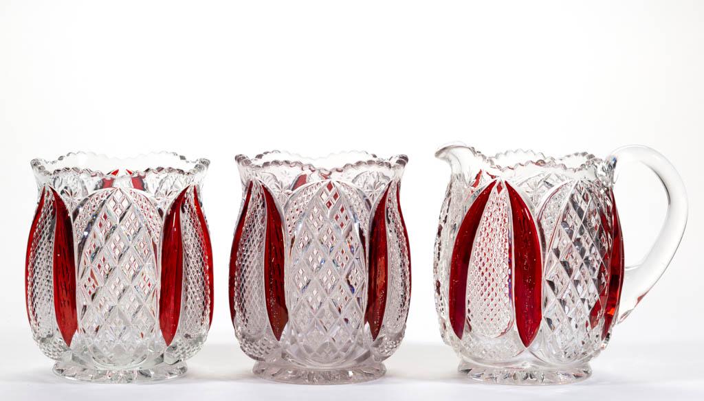 TARENTUM'S HARVARD - RUBY-STAINED TABLE ARTICLES, LOT: TARENTUM'S HARVARD - RUBY-STAINED TABLE ARTICLES, LOT OF THREE, colorless, comprising a creamer and two spooners. Tarentum Glass Co. Pattern introduced in 1896. 4 5/8" to 5" H. Two undamaged; spooner 