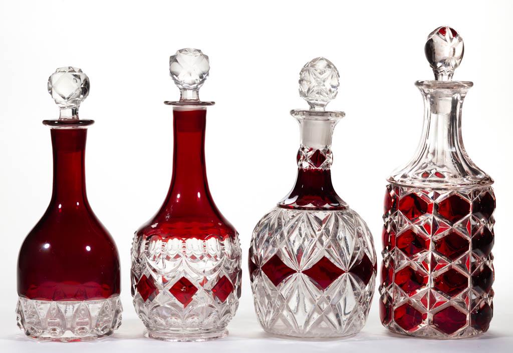ASSORTED EAPG - RUBY-STAINED WINE DECANTERS, LOT OF: ASSORTED EAPG - RUBY-STAINED WINE DECANTERS, LOT OF FOUR, colorless, including a Loop and Block, a Reverse Torpedo, and a Princeton, each with a matching or period pattern stopper. Various makers. Fou