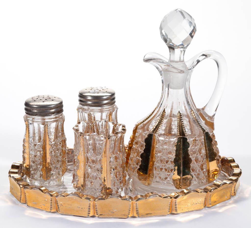 DUNCAN NO. 44 / BUTTON PANEL FIVE-PIECE CONDIMENT SET: DUNCAN NO. 44 / BUTTON PANEL FIVE-PIECE CONDIMENT SET, colorless with gilt decoration, comprising a cruet with period facetted stopper, salt and pepper shakers, toothpick holder, and tray. George Dunc