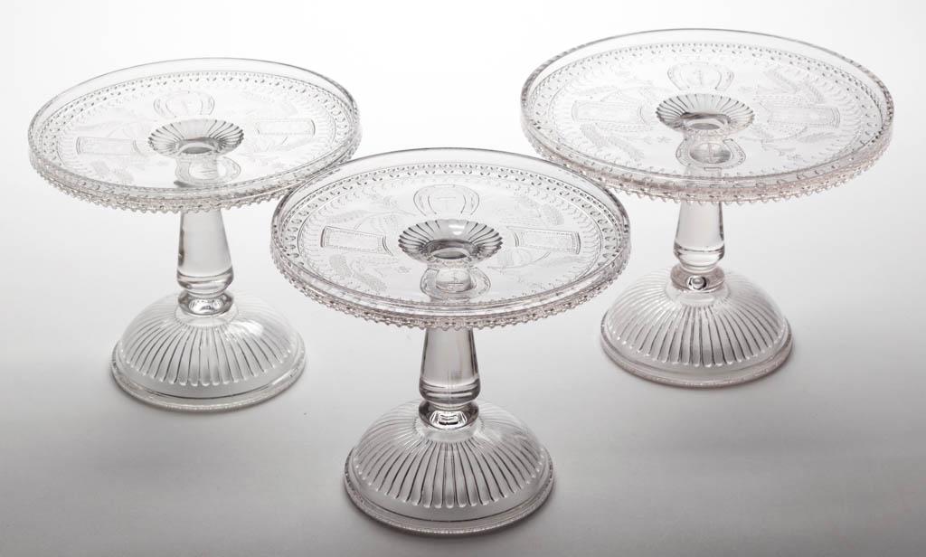 GOOD LUCK / HORSESHOE SALVERS / CAKE STANDS, LOT OF: GOOD LUCK / HORSESHOE SALVERS / CAKE STANDS, LOT OF THREE, colorless. Fourth quarter 19th century.6 1/2" to 6 5/8" H, 8" to 9" D rims. One undamaged; other with some flaking to the knop of the stem; r