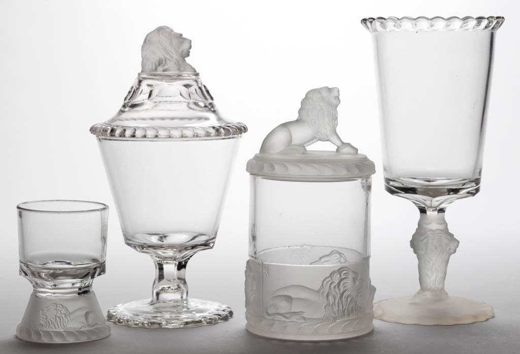 LION - FROSTED TABLE ARTICLES, LOT OF FOUR: LION - FROSTED TABLE ARTICLES, LOT OF FOUR, colorless and frosted, comprising a celery vase, covered sugar bowl, egg cup, and covered jam/pickle jar. Gillinder & Sons. Fourth quarter 19th century.3 5/