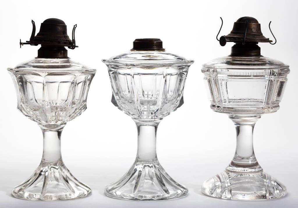 ASSORTED DUNCAN EAPG KEROSENE STAND LAMPS, LOT OF THREE: ASSORTED DUNCAN EAPG KEROSENE STAND LAMPS, LOT OF THREE, colorless, comprising a Zippered Block and two Quartered Block examples, each with a period brass collar. Zippered fitted with a No. 2 "EAGLE" 