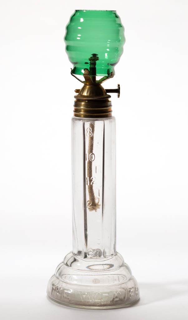 THE WEAVER TIME INDICATING MINIATURE LAMP: THE WEAVER TIME INDICATING MINIATURE LAMP, colorless, unpatterned cylinder-form font with one wide panel embossed with numerals representing nighttime hours of 8 thru 12 and 1 thru 6, circular foot em