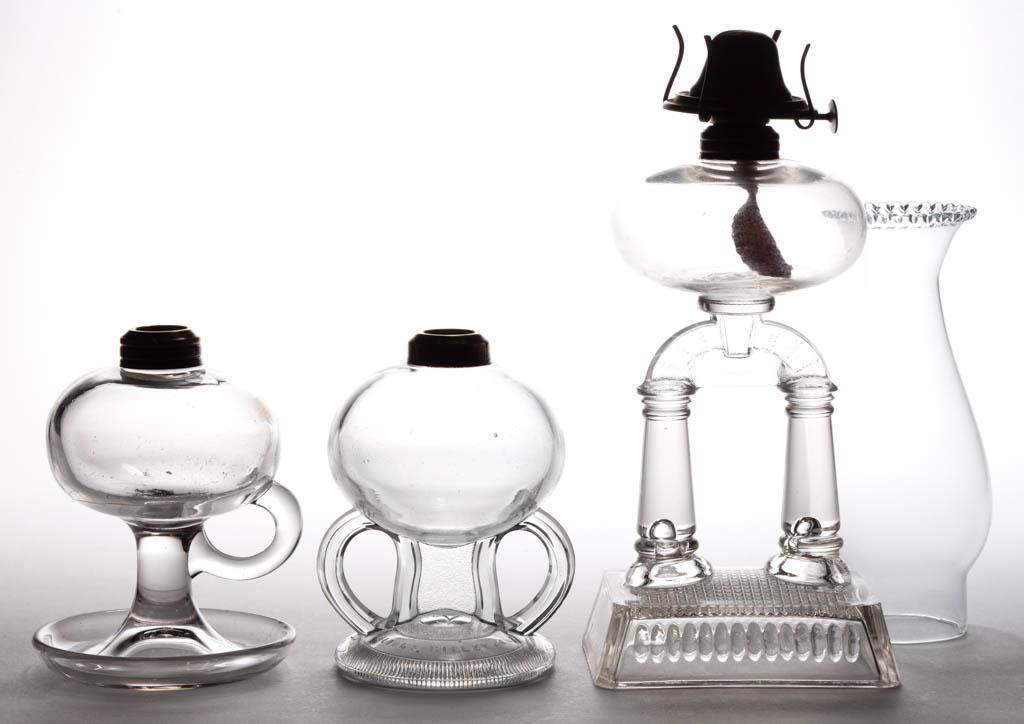 ASSORTED RIPLEY PRESSED GLASS KEROSENE LAMPS, LOT OF: ASSORTED RIPLEY PRESSED GLASS KEROSENE LAMPS, LOT OF TWO, colorless, comprising a Two Post stand lamp and a double-handle finger lamp with patent information embossed to the underside, each having a p