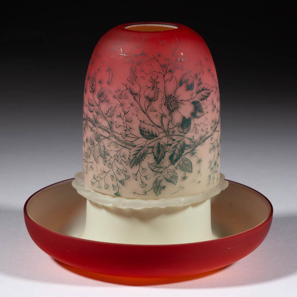 SATIN PEACHBLOW CASED FAIRY LAMP: SATIN PEACHBLOW CASED FAIRY LAMP, deep cranberry shaded to custard, fairy-size dome with Wild Rose pattern, center post base with applied rigaree dome holder, plain rim. Probably Thomas Webb & Sons. F