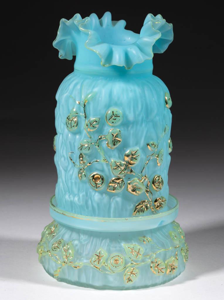CASED AND FIGURAL GLASS FAIRY LAMP: CASED AND FIGURAL GLASS FAIRY LAMP, blue cased with green decoration, figural chimney-shade with a ruffled rim and scattered flowers, matching base with floral decoration. Late 19th/early 20th century