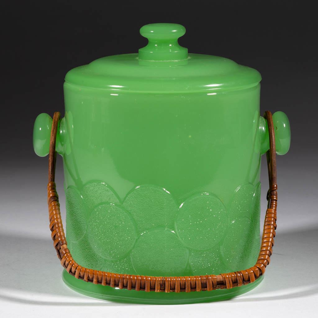 FENTON BIG COOKIES COOKIE JAR: FENTON BIG COOKIES COOKIE JAR, Jadeite, with original wicker handle. Fenton Art Glass Co. Circa 1933. 7 1/4" HOA to top of cover. Undamaged. Provenance: From the John & late Evelyn Teague Collection, 