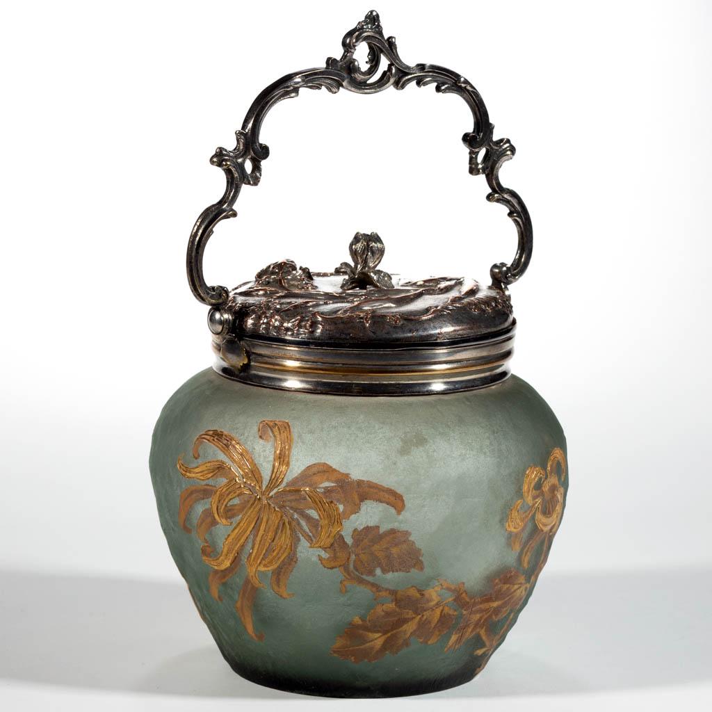 ACID-ETCHED AND ENAMEL-DECORATED CRACKER JAR: ACID-ETCHED AND ENAMEL-DECORATED CRACKER JAR, grey green with etched surface, floral decoration, original metal mount and figural cover, signed to the underside "V S" with a ship medallion in the cent