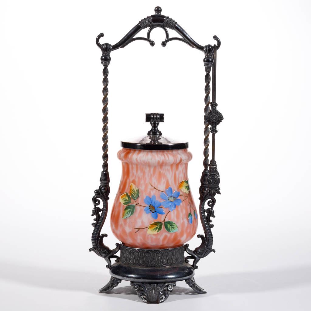 VICTORIAN SPATTER GLASS PICKLE CASTER: VICTORIAN SPATTER GLASS PICKLE CASTER, frosted colorless with opal and orange spatter, baluster form with a deep extension, polychrome-enamel floral decoration, fitted into a "James W. Tufts" quadrupl