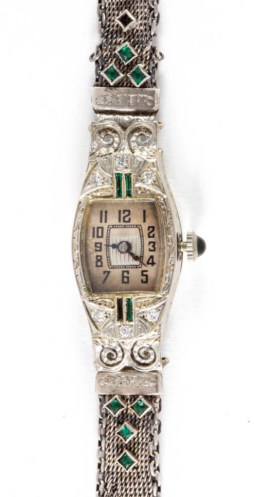 ART DECO 18K WHITE GOLD CASED AND DIAMOND-ACCENTED: ART DECO 18K WHITE GOLD CASED AND DIAMOND-ACCENTED LADY'S WRIST WATCH, case having engraved designs, six melee diamond accents, and three green glass baguette accents, movement marked "BANNER WATCH CO