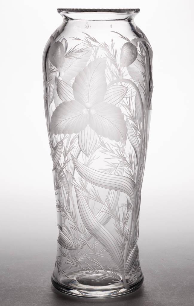 SIGNED TUTHILL WOOD LILY INTAGLIO CUT GLASS VASE: SIGNED TUTHILL WOOD LILY INTAGLIO CUT GLASS VASE, colorless, tall waisted form with ornate cutting with bloomed and budding flowers, notched top rim, polished pontil mark. Tuthill Cut Glass Co. First 