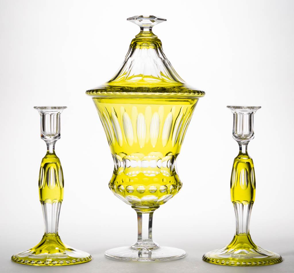 ASSORTED CUT OVERLAY GLASS ARTICLES, LOT OF THREE: ASSORTED CUT OVERLAY GLASS ARTICLES, LOT OF THREE, yellow-green to colorless, comprising two candlesticks with oval and flute cuts, and a large covered chalice with oval and punty cuts. Maker unverifi