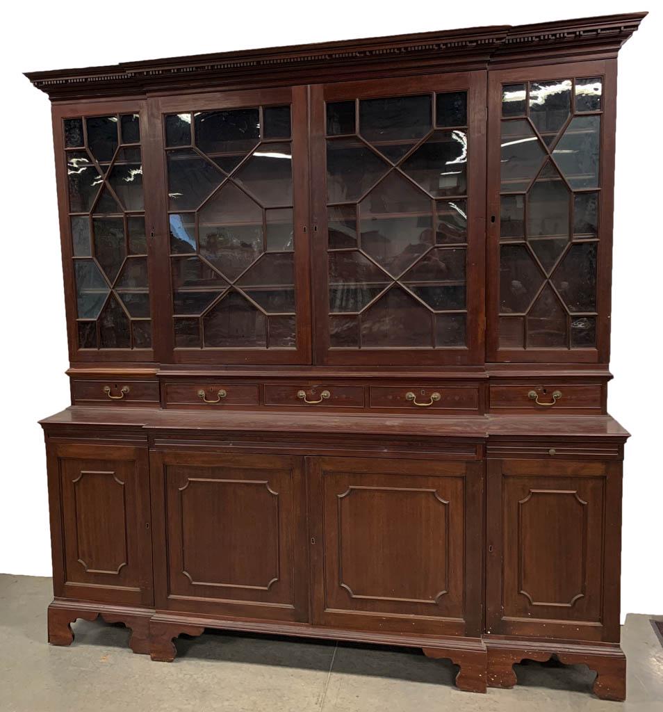 GEORGIAN MAHOGANY BREAKFRONT BOOKCASE: GEORGIAN MAHOGANY BREAKFRONT BOOKCASE, in the manner of Thomas Chippendale, two-piece construction, the upper three-part bookcase with molded cornice over dentil course above four hinged doors exhibit