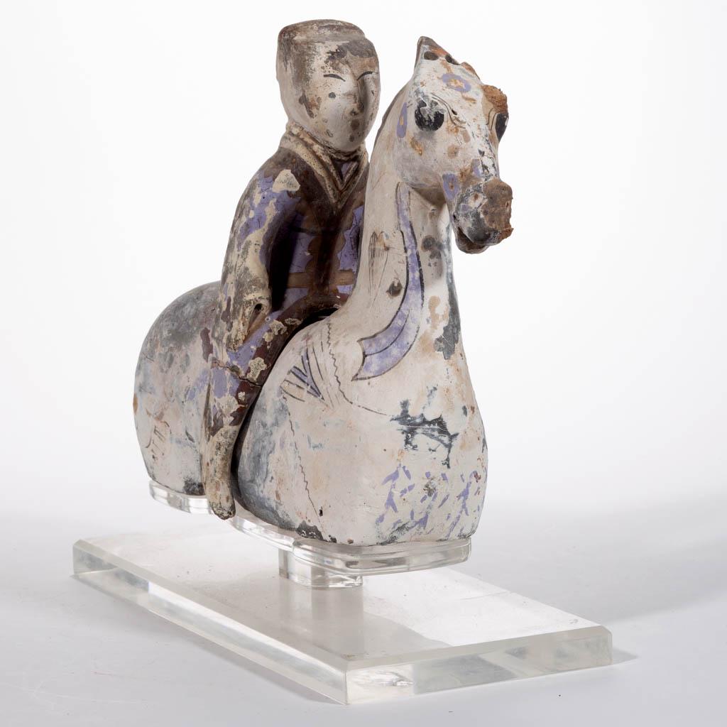 CHINESE EARTHENWARE HORSE AND RIDER TWO-PIECE TOMB: CHINESE EARTHENWARE HORSE AND RIDER TWO-PIECE TOMB FIGURE, each with remnants of pigment, including an acrylic stand. A descriptive sheet from Arch Angel Antiques, Hong Kong, dated Jan. 12, 1998 and a