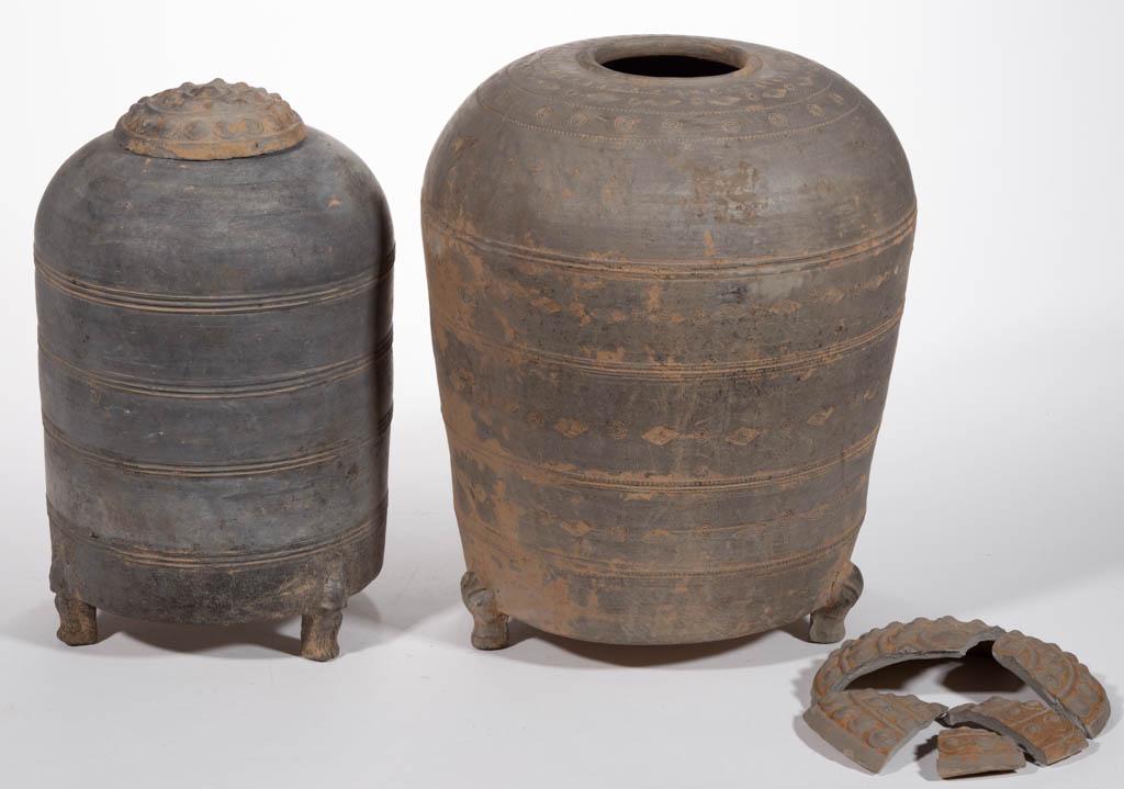 CHINESE EARTHENWARE GRANARY JARS, LOT OF TWO: CHINESE EARTHENWARE GRANARY JARS, LOT OF TWO, each having a tall vessel-form body raised on three feet with molded fronts including a possibly original cover, taller example with stamped and incised d