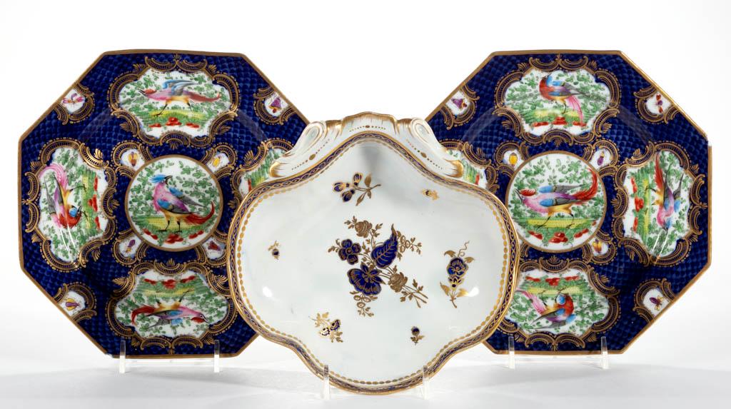 CONTINENTAL PORCELAIN TABLE ARTICLES, LOT OF THREE: CONTINENTAL PORCELAIN TABLE ARTICLES, LOT OF THREE, comprising two octagonal plates featuring bright polychrome birds and insects on cobalt fish scale ground, and a shell-shaped dish having cobalt and